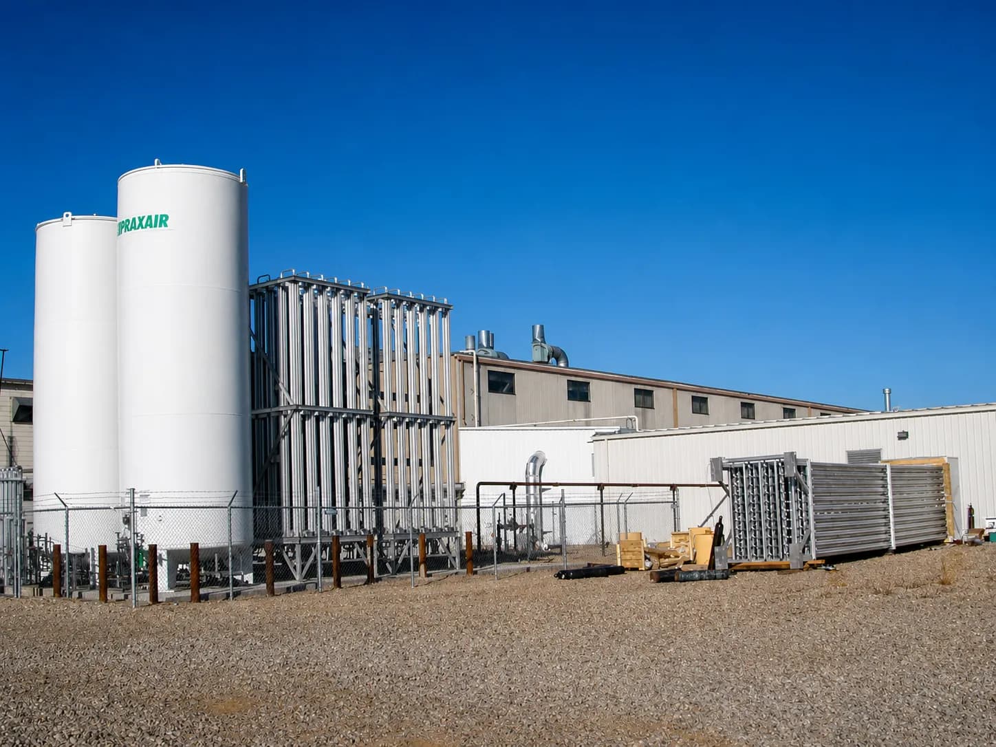 A bulk tank installation with two Praxair cryogenic liquid storage tanks feeding installed FWM ambient air vaporizers, with a third vaporizer staged on-site ready to be set in place.
