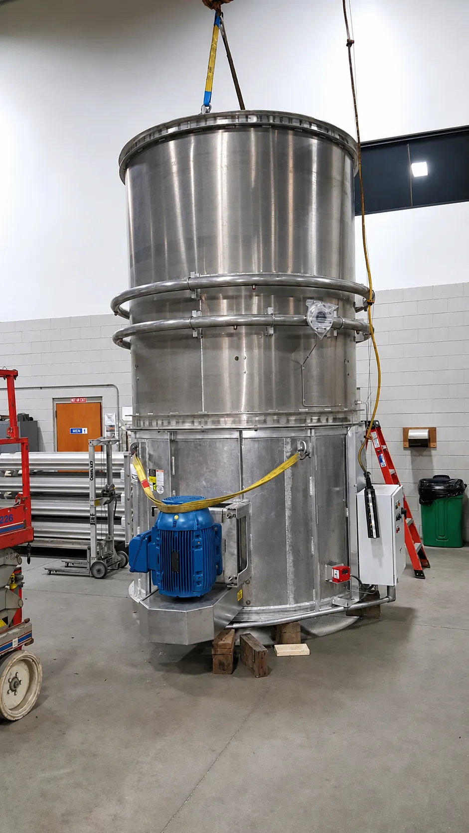 A custom stainless steel assembly rigged to an overhead hoist at FWM