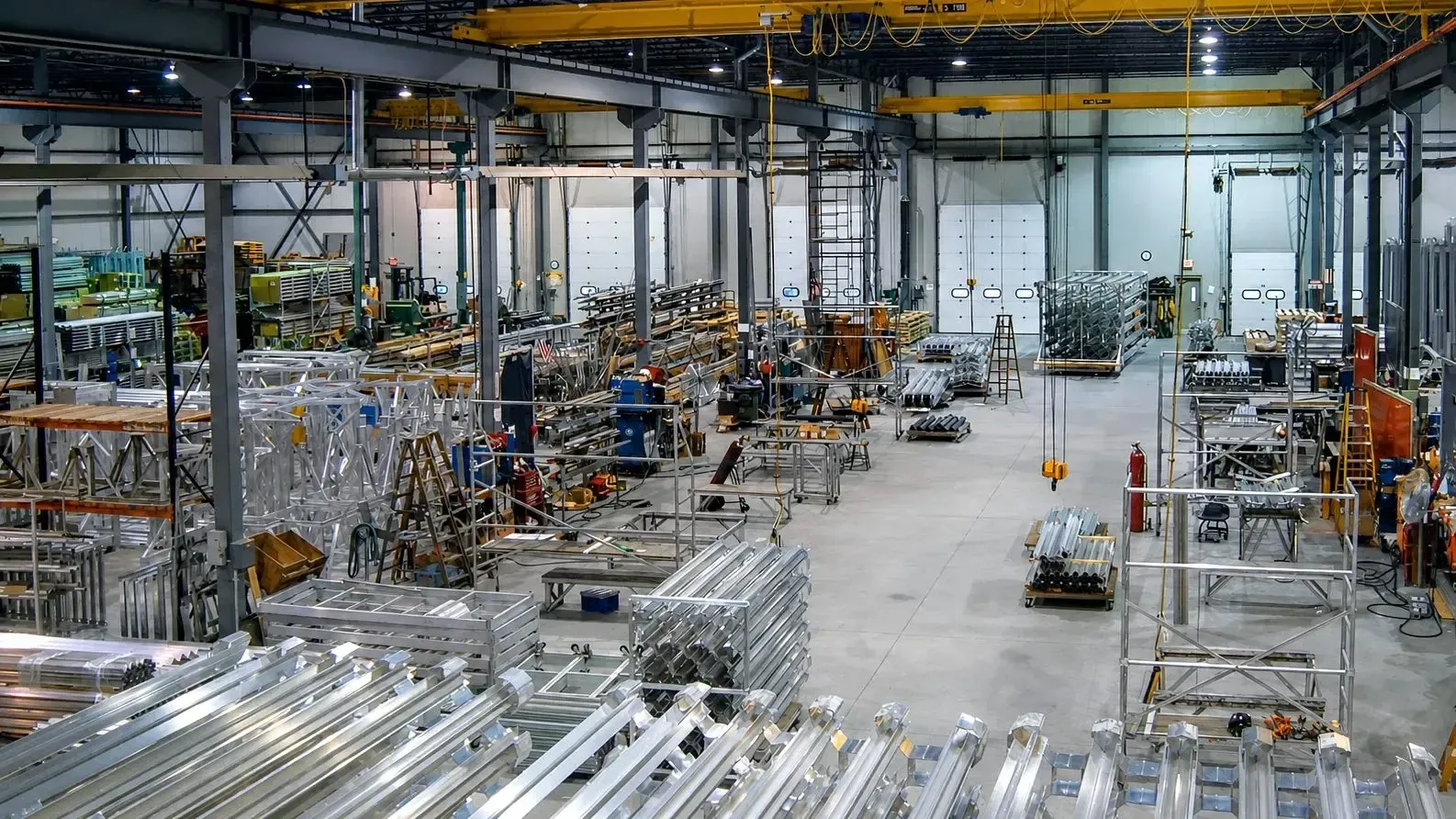 A wide view of the FWM production floor with CNC machines, saws, weld cells, and overhead bridge cranes