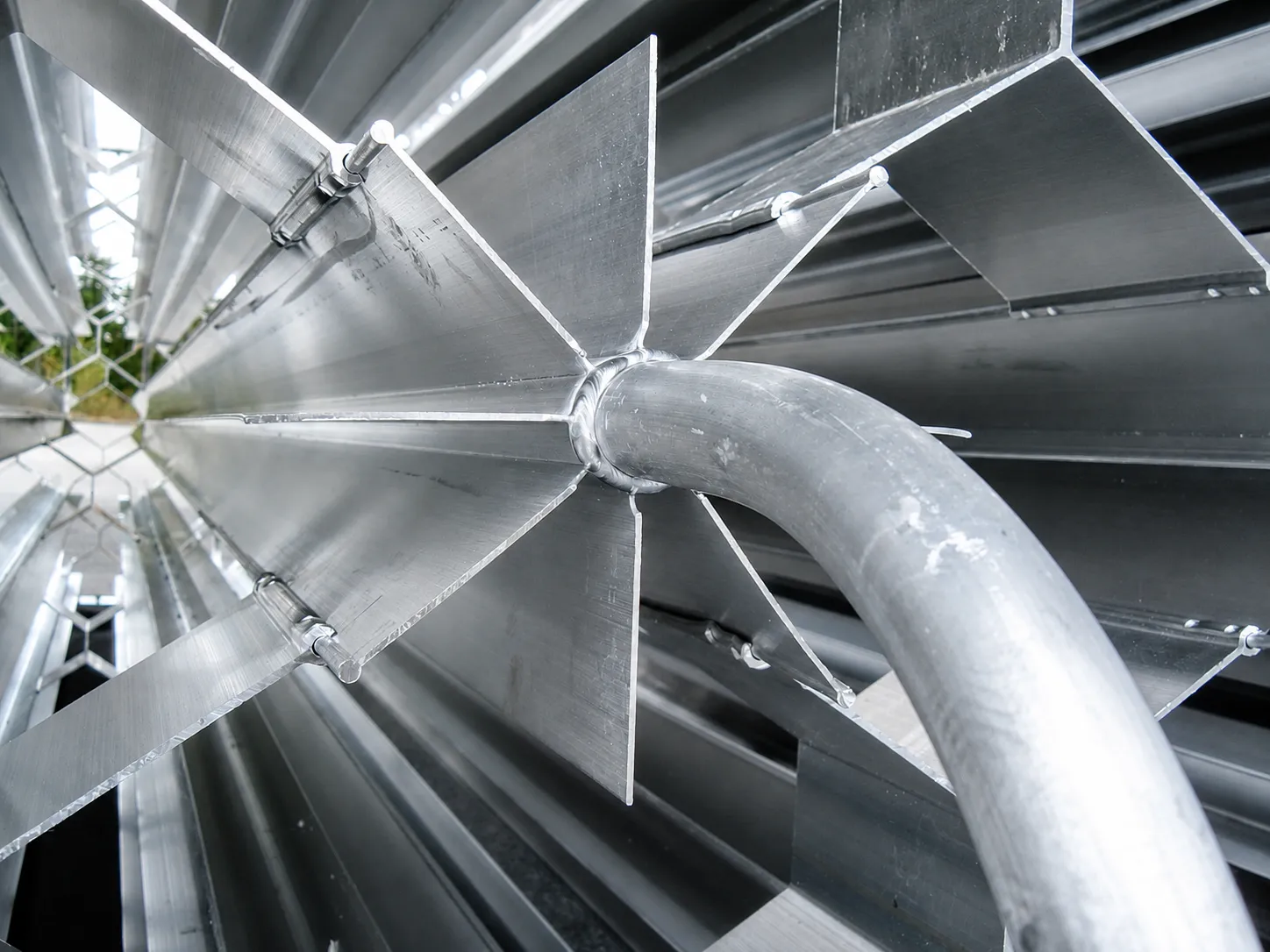 Macro view of the welded aluminum return band joining extruded fins with crimped joints at the center hub