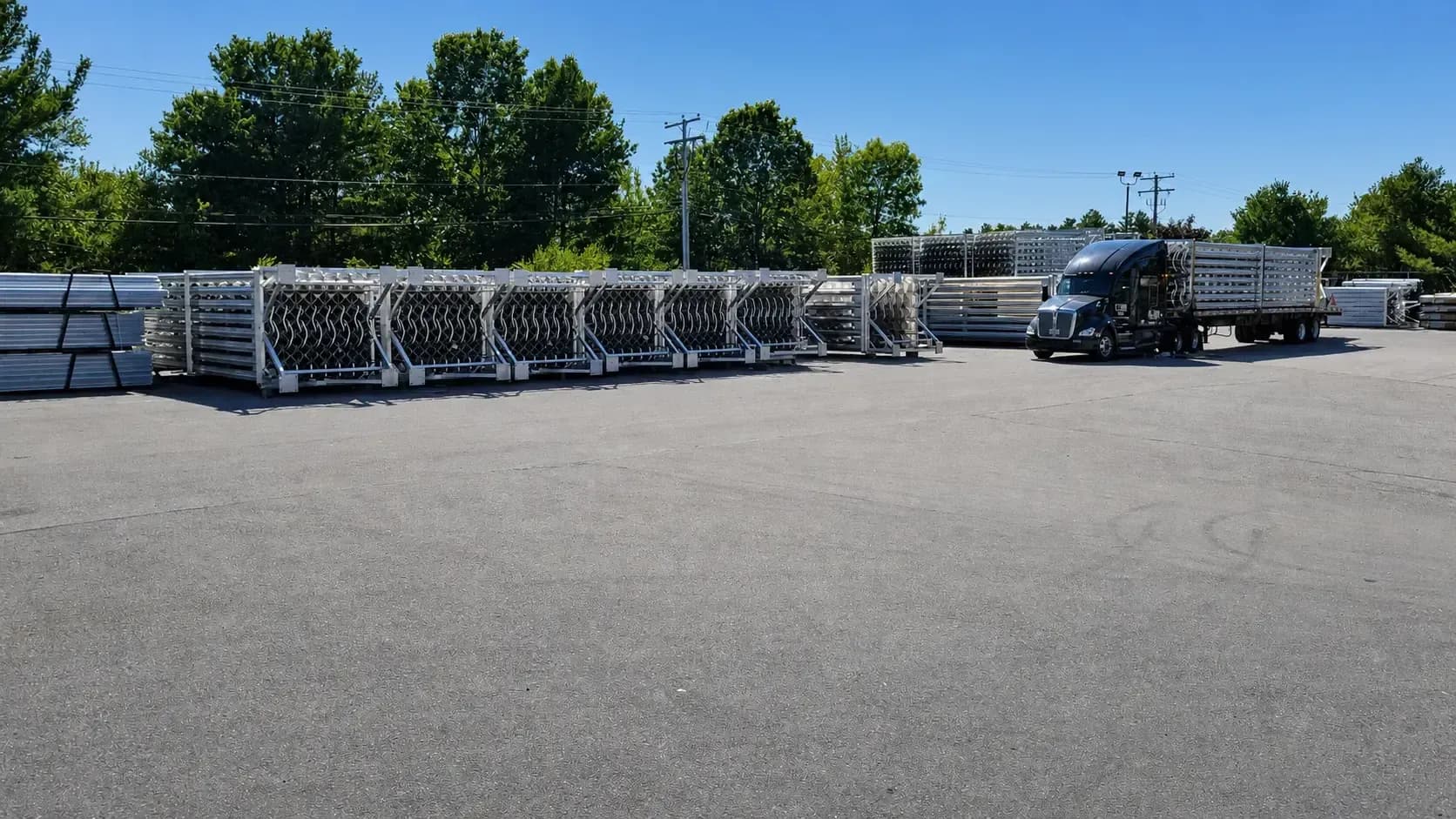 Rows of large finned aluminum vaporizers staged in shipping frames in the FWM yard in Hudson, New Hampshire, with a tractor-trailer loading for outbound delivery.