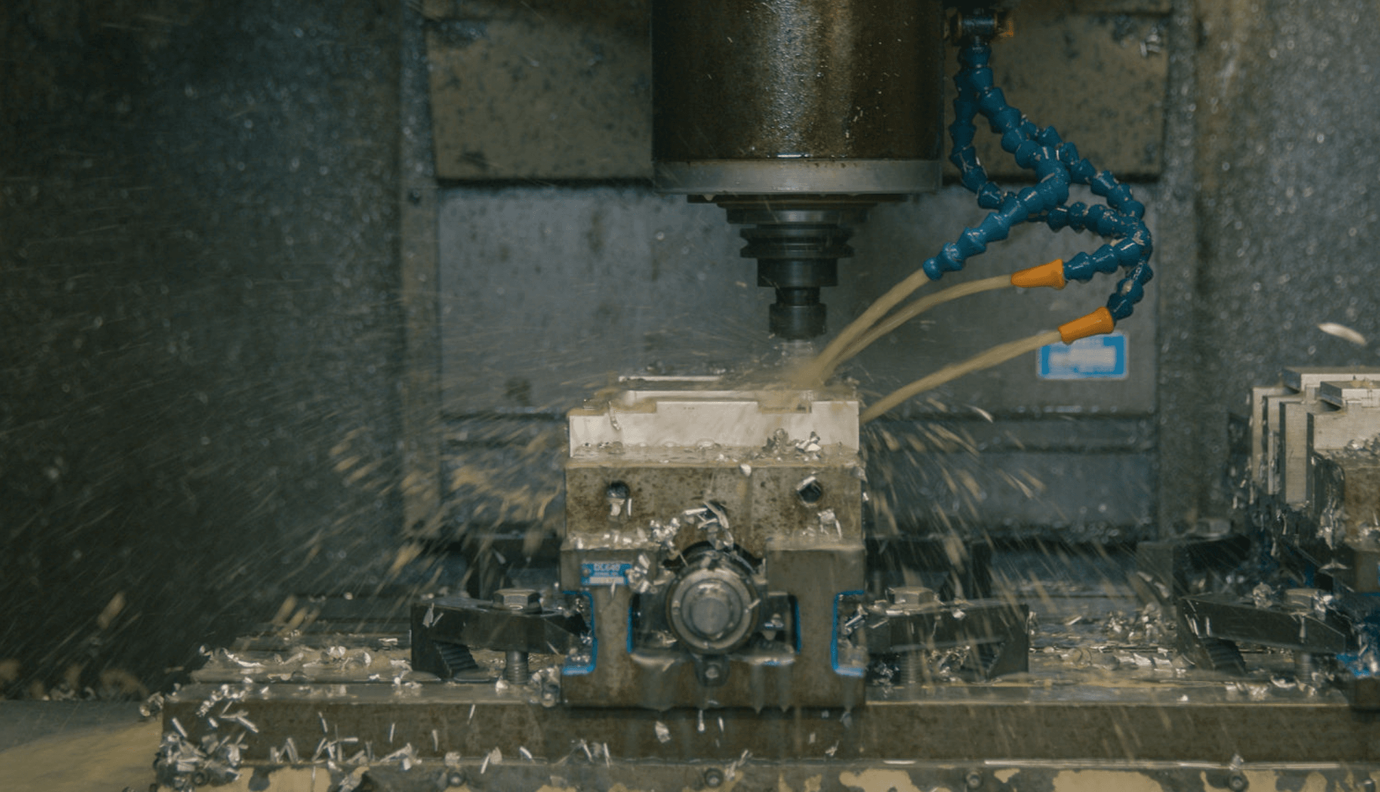 A CNC machining center at FWM milling an aluminum part with flood coolant