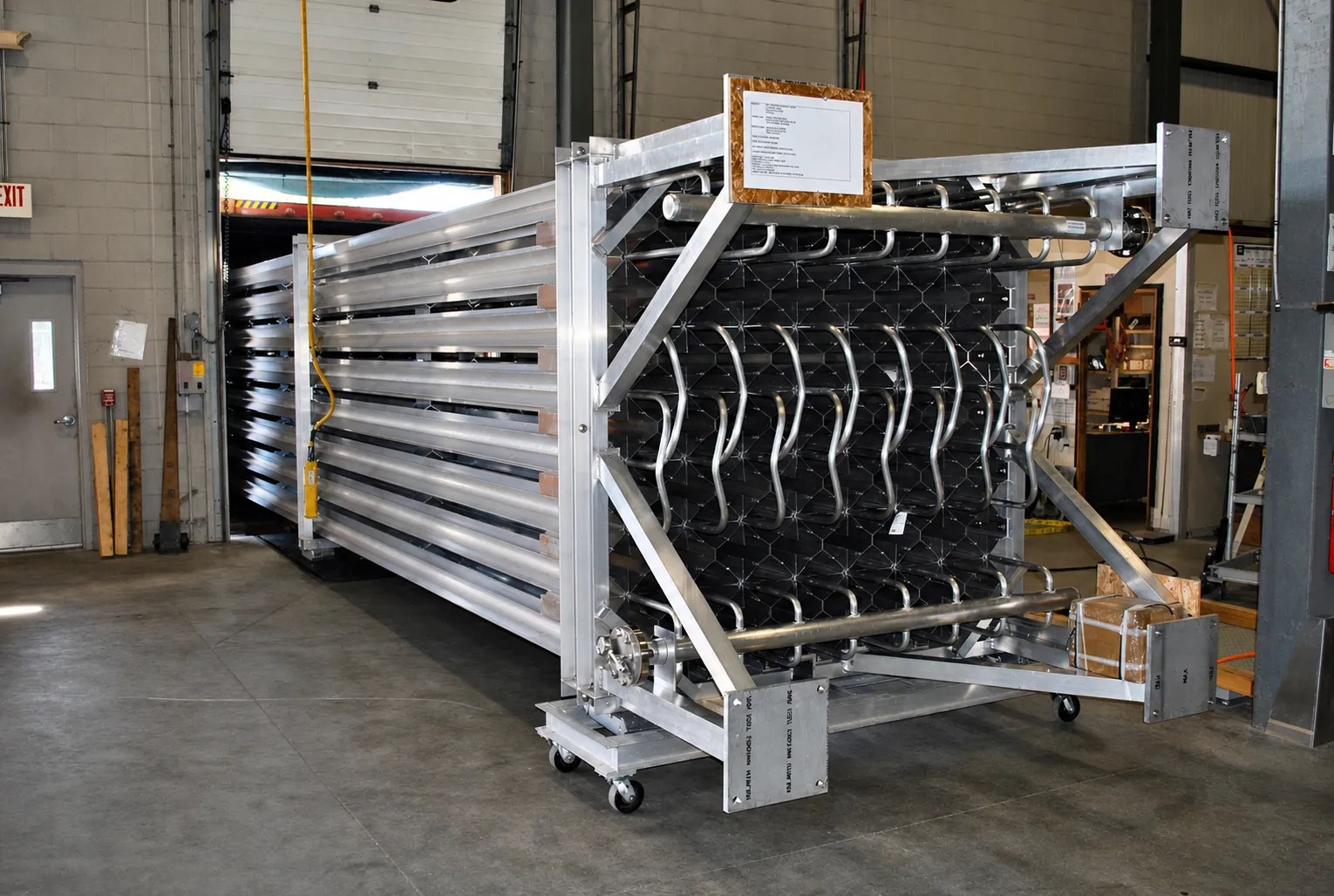 An FWM vaporizer core array on a wheeled fixture at the dock door being prepared for container loading.