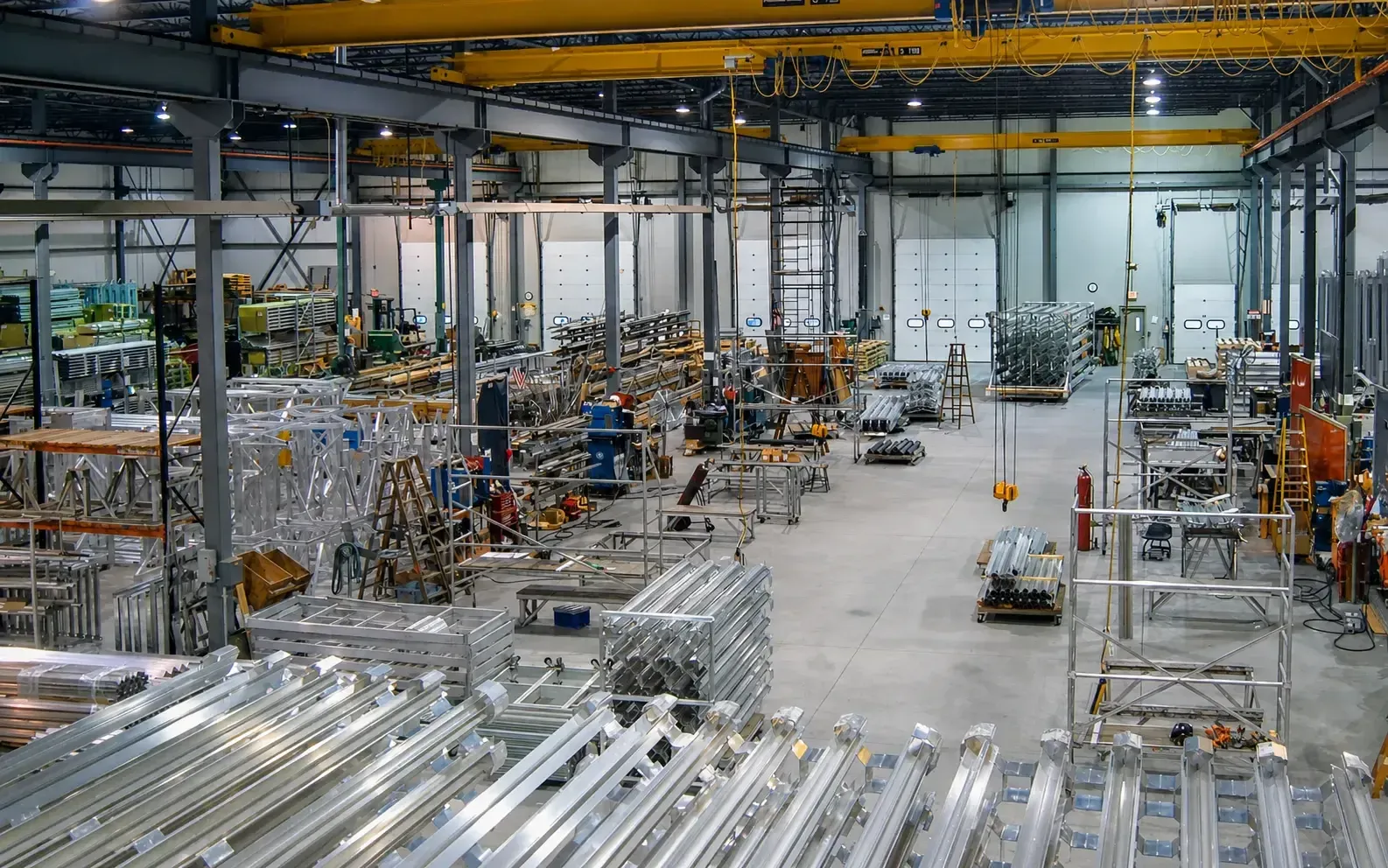 A wide overview of the FWM production floor with workstations, cranes, and assemblies in process